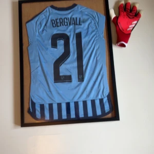 Djurgården tröja signad - En djugården signad tröja tocmak och guliksen har signat så den är super svår att få tag på pris kan kanske diskuteras men kanske inte men tröjan är signad av nästan hela laget handsken i bilden är från djugårdensmålis behöver betala extra om du vill ha med handsken( priset på annonsen är utan handsken så om du ska köpa skriv till mig så ändrar jag priset 