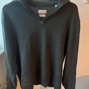 Mörkgrå merinotröja - Snygg mörkgrå långärmad tröja från These Glory Days i mjuk merinoull. Tröjan har en quarter zip dragkedja vid halsen och klassisk passform. Skriv vid frågor priset går att diskutera.