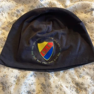 Svart DIF mössa med klubbmärke - Mörkblå djurgården mössa. Fint skick,knappt använd 