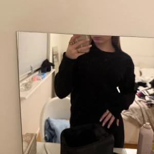 Svart stickad tröja med rund hals - En svart stickad tröja med rund hals och långa ärmar. Tröjan har en enkel och clean look, perfekt att slänga på sig till jeans eller kjol. Mjuk och skön känsla, passar dig som gillar basic vibes.