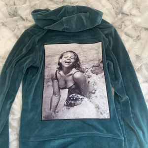 LIMITATO zip up hoodie  - LIMITATO hoodie i mjuk mörk grön sammet med hel dragkedja, huva och två fickor med dragkedja. Baksidan har en stor svartvit fotoprint med retrovibbar. Snygga detaljer som svarta snören och silvriga metalldetaljer. Perfekt för dig som gillar unika plagg. OBS! Har ett litet hål i främre fram ficka, de sista bild.