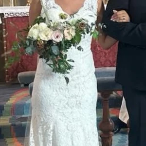 Bröllopsklänning  - Elegant långklänning i vit spets med figurnära passform och vackert släp. Klänningen har ett romantiskt blommigt spetsmönster och är ärmlös, perfekt för dig som vill ha en klassisk och tidlös look. Passar dig som vill känna dig extra speciell på stora dagen.  Jag väger ca 60kg och är 166cm lång och bar 3cm klack på mitt bröllop. Slöja finns om man vill ha den till.   Pris går att diskutera 