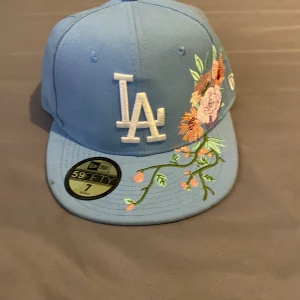 Blå LA New Era keps med blommor - Snygg blå 59FIFTY keps från New Era med LA-logga 