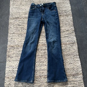 Blå bootcut jeans från Gina Tricot - Mörk blå bootcut jeans från Gina Tricot i storlek 164. Justerbar midja och använda endast ett fåtal gånger.❣️