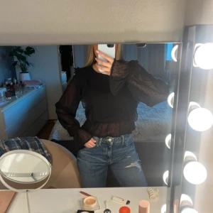 Svart blus med volanger från NA-KD - Svart blus från NAKD i storlek Xs. 