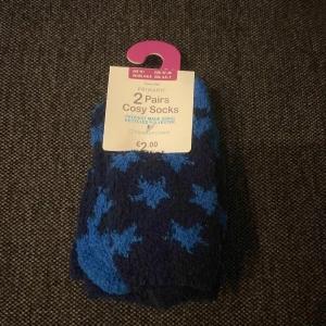 Blå cosy socks med stjärnor - Två par mjuka och fluffiga cosy socks från Primark i mörkblå och blå färg med stjärnmönster. Perfekta för att hålla fötterna varma och sköna hemma. Snyggt mönster som sticker ut och passar dig som gillar färg.