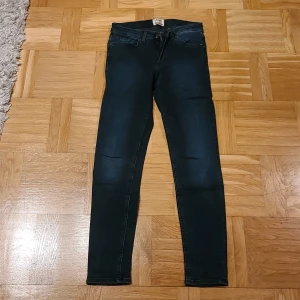 Skinny jeans Acne Studios mörkblå 26/32 - Mörkblå skinny jeans från Acne Studios, modell Skin 5 Deep. Klassisk femficksdesign med dragkedja och knapp framtill. Materialet är 92% bomull, 5% polyester och 3% elastan för en stretchig och bekväm passform.