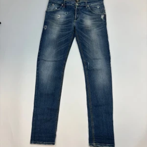 Blå Replay Dondup George med slitningar - Snygga blå Dondup jeans i modellen George med slitna detaljer och lätt tvättad look. 