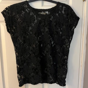 Svart spetsblus från Ofelia - Säljer en spets top, perfekt till dig som gillar att klä upp vardagen eller till dig som ännu inte hottt toppen till jul eller nyår❤️ skulle säga att storleken är S/M