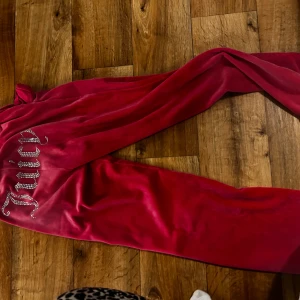 Juicy Couture rosa mjukisbyxor XS - Snygga rosa mjukisbyxor från Juicy Couture i storlek XS. Byxorna har glittrande Juicy-text på baksidan, snörning i midjan och är gjorda i mjuk sammet. Perfekta för en chill och trendig look.