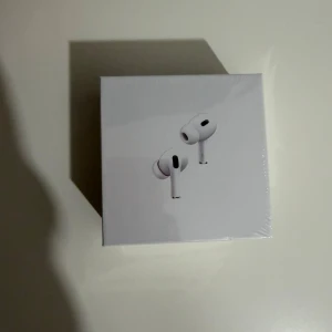 AirPods Pro - Säljer ett par Apple AirPods Pro i originalförpackning med laddningsetui, extra öronkuddar och laddningskabel. Allt ser komplett ut och i mycket gott skick, vissa bilder visar obruten plast. Perfekt för dig som vill ha aktiv brusreducering och hög ljudkvalitet.