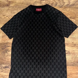 Gucci Svart T-Shirt  - Säljer en svart Gucci T-shirt i storlek S. Tröjan är oanvänd och i mycket bra skick, helt utan fläckar eller slitage. Klassisk, stilren design i mjuk och lyxig bomull med den välkända Gucci-kvaliteten. Passar perfekt för dig som vill ha en tidlös och exklusiv T-shirt som lyfter vilken outfit som helst.