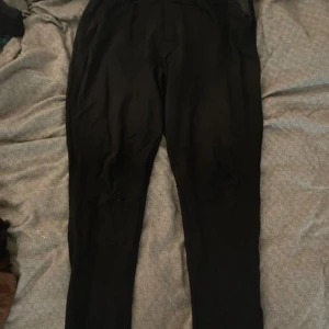 Svarta byxor från 157 i storlek XL - Svarta byxor från 157 i storlek XL. De har en rak passform med elastisk midja och sidofickor. Materialet känns mjukt och lätt, perfekt för chill dagar. Snygg och enkel design som funkar till det mesta.