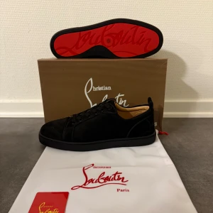 Svarta sneakers från Christian Louboutin  - Säljer ett par svarta sneakers från Christian Louboutin med ikonisk röd sula och broderad logga på hälen. Helt nya!😊 Skickar samma dag ✅kan gå ner i pris om det är en snabb affär👍skickar med en nocco på köpet 🍾 Hör av er vid frågor!