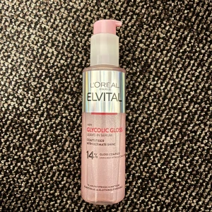 L'Oréal Elvital Glycolic Gloss Serum - Säljer en L'Oréal Elvital Glycolic Gloss leave-in serum med 14% gloss complex. Flaskan är rosa med holografisk etikett och har en praktisk pump. Innehåller 150 ml och är perfekt för att ge håret extra glans och mjukhet.
