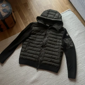 Olivgrön Moncler cardigan med huva - Olivgrön cardigan som är använd en gång!  DU VET VARFÖR DEN ÄR BILLIG. Storlek XXL men sitter som en XL/L. Nfc funkar