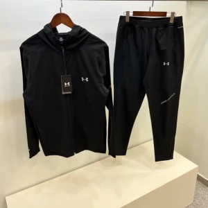 Svarta träningsbyxor från Under Armour - Svarta träningsbyxor från Under Armour med smal passform och diskret logga på låret. Byxorna har elastisk midja, dragkedjor vid bensluten och är tillverkade i ett lätt och funktionellt syntetmaterial som andas. Perfekta för träning eller sport.