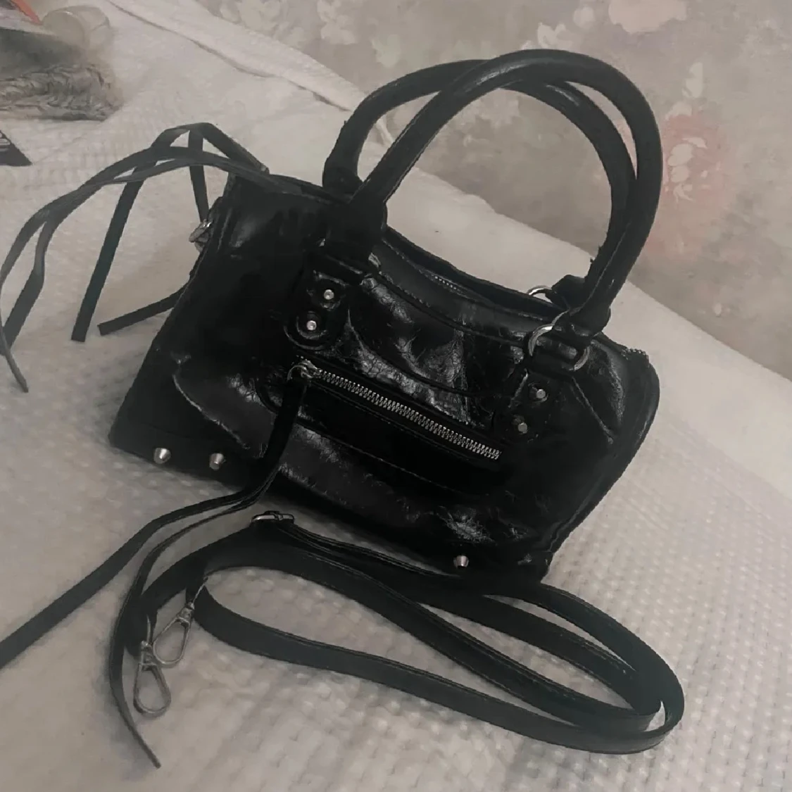 Svart handväska med dragkedja och nitar