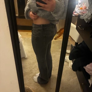 lågmidjade mörkgrå bootcut jeans - säljer ett par lågmidjade utsvänga gråa jeans i storlek 34