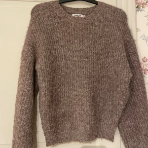 Beige stickad tröja från ONLY - Mysig beige stickad tröja från ONLY i storlek S. Tröjan har en grovstickad struktur, rund halsringning och långa ärmar. Perfekt för lager-på-lager och chill höst- och vinterstil. Den är jättemjuk och skön till vintern. Köpte på Zalando.