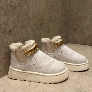 NYA vinterskor med guldkedja - Säljer mina oanvända fantastiskt snygga Uggs med en guldkedja vid fotlänken. De är extremt bekväma och varma till vintern. De är som att gå på moln när man han de på sig🤍 passar till allat såsom tights eller vacker finteroutfit ❄️