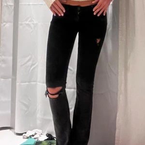 Unika Svarta jeans med slitningar - Snygga svarta jeans med slitningar på låret och knät. Bootcut as snygga köpte för länge sedan de har dock en liten reva där bak som jag kan ta bild på därav priset. De går dock enkelt att sy igen och kommer inte synas så länge man syr igen med svart tråd❣️