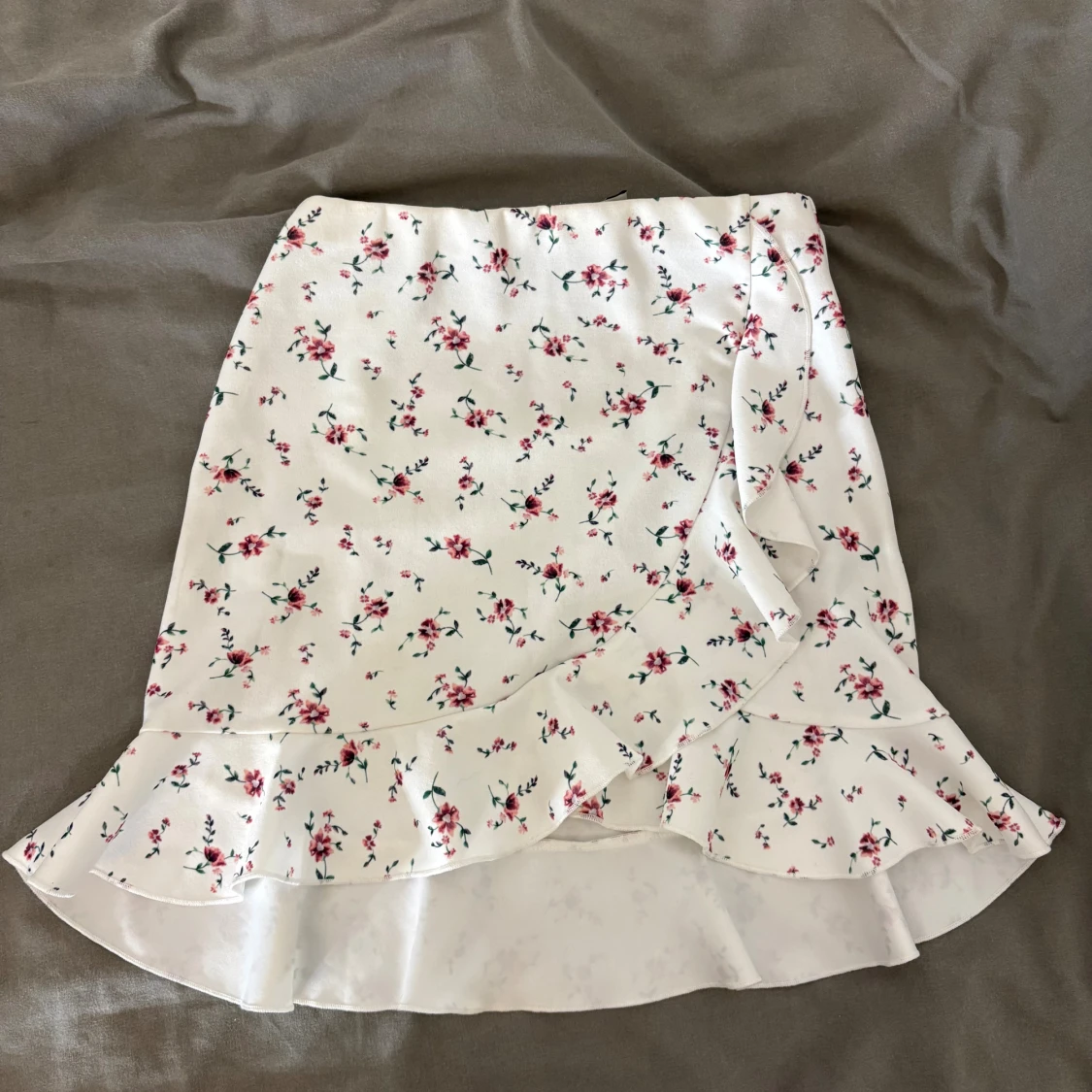 Vit blommig omlottkjol med volang