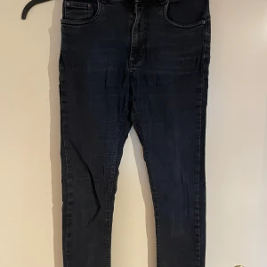 Svarta skinny jeans från Samsøe Samsøe - Snygga svarta skinny jeans från Samsøe Samsøe med klassisk femficksdesign och smal passform. Jeansen har hög midja och är tillverkade i mjukt bomullsmaterial med lite stretch för extra komfort. Perfekta för dig som gillar en stilren och modern look.