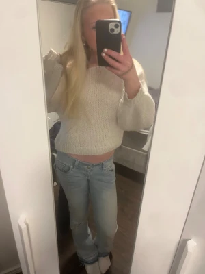 Ljusblå bootcut jeans med slitningar - Säljer ett par ljusblå jeans från G RISE med bootcut passform och låg midja. Jeansen har slitna detaljer vid knä och benslut samt klassiska fem fickor. Materialet är jeans och de har en snygg, avslappnad vibe. Tror inte att modellen finns kvar på deras hemsida, nypriset var 1500 så därav priset då de heller inte finns att köpa längre!!💘💘 Har även lagt ner dom då  de var korta. Lätta t sy upp igen om man vill. De är i storlek S men funkar xxs-xs. De är stretchiga 