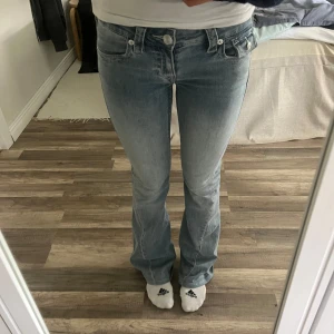 True Religion Joey ljusblå bootcut Jeans - Ljusblåa bootcut True Religion Joey jeans . De är i mjuk denim med lågmidjad dragkedja💗 Nersydda ca 4cm (innerbenslängd 75cm) Mycket bra skick, använda typ 2 ggr. Säljer pga att jag ångrade mig och hellre vill ha ett par andra byxor😝