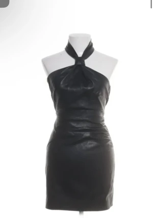 Svart halterneck klänning från adoore - Snygg svart kort klänning i skinnimitation med halterneck och åtsittande passform. Klänningen är köpt ifrån adoore och använd endast en gång. Har inga deffekter. Perfekt till nyår.