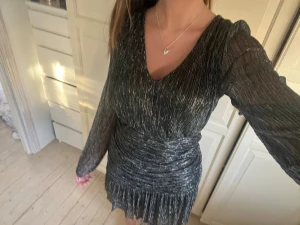 Nyårsklänning - Säljer denna svarta klänning med silver detaljer från meet me there! Perfekt till nyår! Prislapp kvar