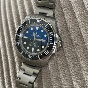  Deepsea Sea-Dweller blå/svart -  Deepsea Sea-Dweller med cool blå till svart urtavla och robust silverfärgat armband i stål. Klockan har en rund form, tydliga index och datumfunktion. Perfekt för dig som gillar exklusiva och sportiga klockor med riktigt grym design.