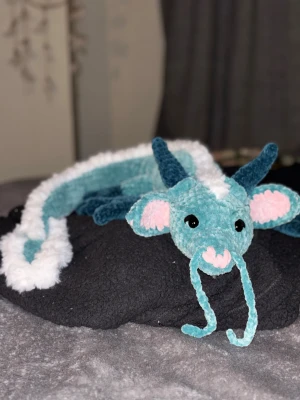 Virkad japansk drake🩵🐉 - En noggrant handgjord, virkad drake i turkost och vitt garn med rosa detaljer, perfekt som julklapp eller present! 