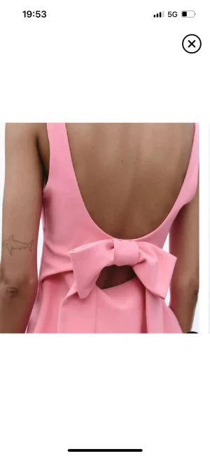 Rosa linnetopp med rosett och öppen rygg - Supersöt rosa linnetopp med fyrkantig urringning och breda axelband. Toppen har en öppen rygg med en stor rosett som detalj. Figurnära passform och lätt utsvängd nertill, perfekt till jeans eller kjol. Används endast vid ett tidigare tillfälle❣️