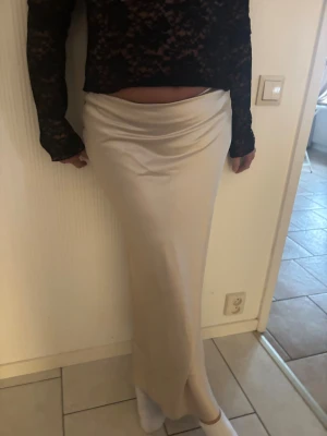 Champagnefärgad långkjol från NA-KD - Midi skirt i satin. Snygg och stilren långkjol från NA-KD i champagnefärgad satin. Aldrig använd, lappen på 