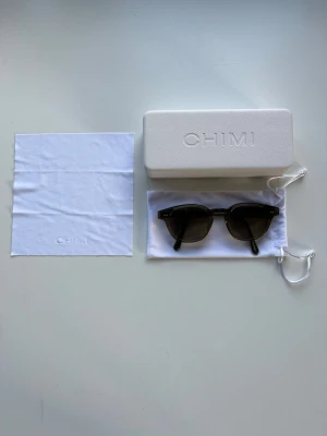Gröna solglasögon från CHIMI - Snygga solglasögon från CHIMI med klassisk rundad form och transparent båge. Modellen är 01 GREEN och kommer med originalfodral och putsduk. Skriv om du har några funderingar .