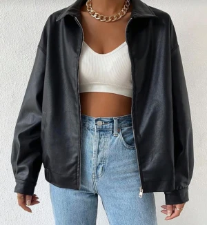 Svart skinnjacka från Mobula Sound - Stilren svart skinnjacka i PU-material från Mobula Sound. Jackan har klassisk krage, dragkedja framtill och en loose passform som ger en cool vibe. Perfekt att slänga över en crop top och jeans för en trendig look eller till sommarens festivaler💕💕