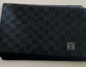 Louis Vuitton  halsduk - Exklusiv halsduk från Louis Vuitton i mörkgrått med klassiskt rutigt mönster och LV-logga. Tillverkad i 100% ull, mjuk och varm för kyliga dagar. Perfekt accessoar för dig som vill ha en lyxig och stilren look.