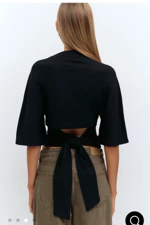 Svart omlottopp med knyt i ryggen - Säljer en svart omlottopp med trekvartsärmar och snygg knytning i ryggen💕 jätre bra skick och har inga defekter💕