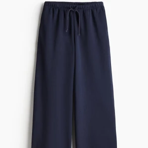 Mörkblå mjukisbyxor med snörning - Snygga mörkblå mjukisbyxor med breda ben och elastisk midja med snörning. Byxorna har en loose passform och är tillverkade i mjukt material som är perfekt för chill dagar. Fickor på sidorna för extra bekvämlighet. Storlek S. Helt ny i förpackning. Glömt returnera beställning därav säljes.