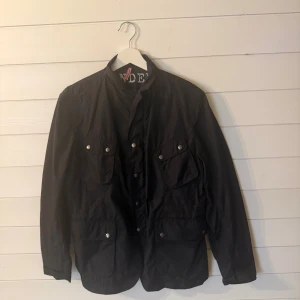 Svart Fieldjacka från J.Lindeberg - Svart Fieldjacka från J.Lindeberg med tryck på insidan, flera fickor med knappar och hög krage. Jackan har en stilren look och är tillverkad i lätt polyester, perfekt för dig som gillar minimalistisk design och streetstyle en perfekt Julklapp. Nypris ligger på runt 4000kr  hör av dig vid frågor kan släppas för billigare vid snabbaffär🙌