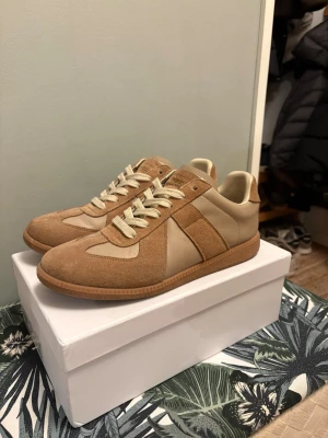 beige skor -  i beige med snygga paneler i mocka och skinn. Klassisk rund tå, platt gummisula och krämfärgade snören. Ikonisk design som passar perfekt till streetwear och casual outfits. Kommer med originalkartong.
