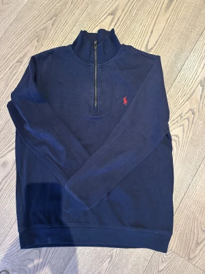 Marinblå half zip tröja Polo Ralph Lauren - Snygg marinblå långärmad tröja från Polo Ralph Lauren. Storlek S