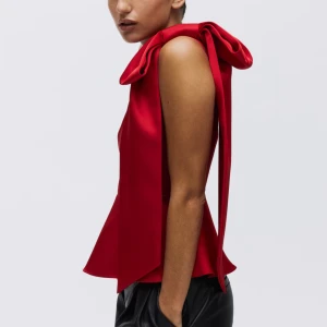 Röd oneshoulder topp med rosett - Säljer en snygg röd oneshoulder topp från HM . Med stor rosett på axeln och volang nedtill. Slutsåld på hemsidan🤗💕Lappen kvar