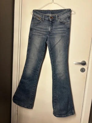 Blå bootcut jeans från Wrangier  - Blå bootcut jeans från Wrangier i bra skick. Storlek rakt över är 35 och innerbenslängd är 80. Dm vid frågor! 