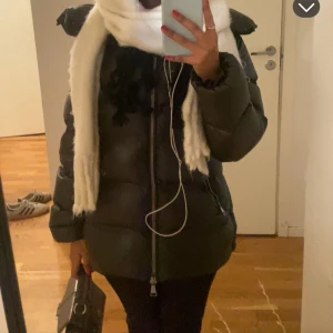 SÄLJER!!! Mörkgrön pufferjacka med dragkedja - Säljer en mörkgrön pufferjacka med hög krage och stora, quiltade partier. Jackan har en rak passform, långa ärmar och tvåvägsdragkedja framtill. Materialet är glansigt och syntetiskt, perfekt för kalla dagar. Snygg och trendig look som håller dig varm.