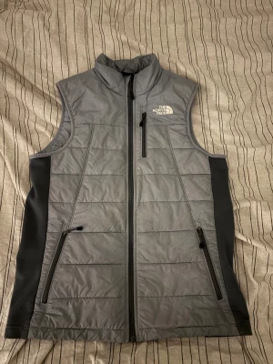 Grå pufferväst från The North Face - Tjenare, säljer nu min väst då den inte kommer till användning, köpt på Jd sports i stockholm men säljs inte längre. 