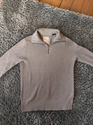Ljusgrå ribbad half zip stickad tröja - Säljer en ribbad ljusgrå stickad halfzip tröja!Perfekt för dig som gillar att vara stilren och som vill ha en chill och snygg. Hör av dig vid frågor och funderingar. Mhv