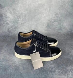 Lanvin sneakers i mörkblå mocka - Snygga skor från lanvin. Säljer nu mina stilrena lakrits kolor i nyskick för en trevlig peng. Säljer de billigt eftersom jag köpt vinterskor och sälja av lite skor från garderoben. Slå en pling vid intresse! Strl 42-43 uk8